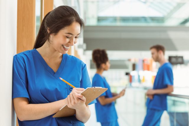 Medical student taking notes in hallway at the university