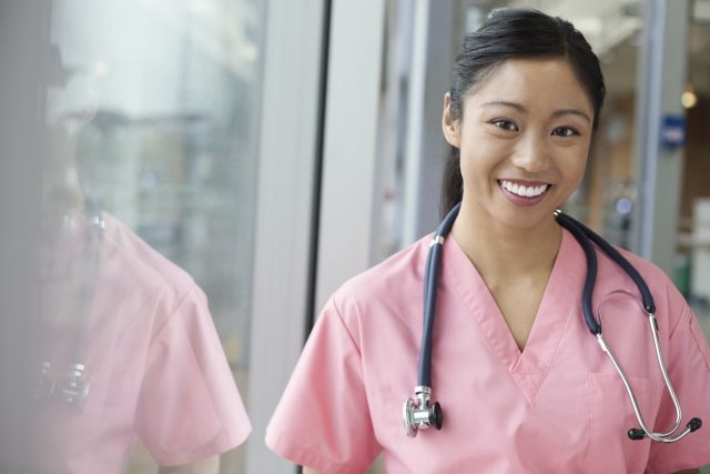 Portrait of a happy female nurse in pink scrubs