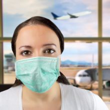 Airport Caucasian woman tourist boarding plane taking a flight in China wearing face mask. Coronavirus flu virus travel concept banner panorama.