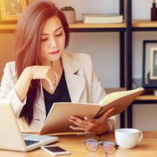 young Asian business woman working at workplace. beautiful Asian woman in casual suit working with reading book, prepare for meeting or interview in modern office. freelance and start up business in Asia