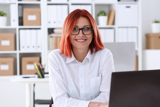 Business woman redhead office portrait sit table