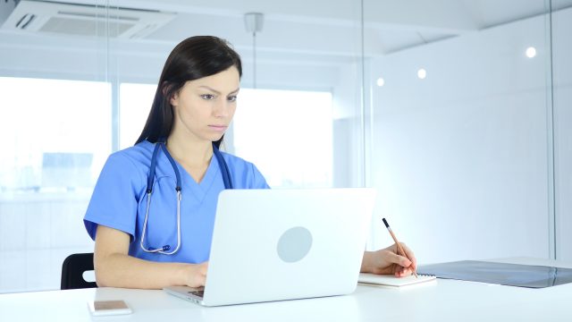 Doctor Writing Medicine for Patient, Sitting in Front