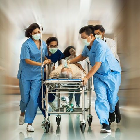 A group of ER nurses are rushing a patient in a hospital