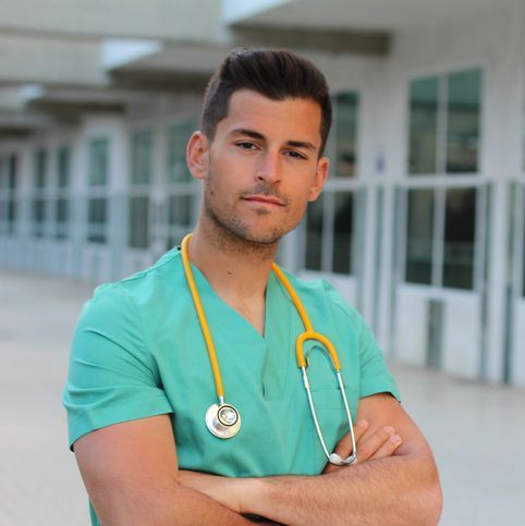 A Male Registered Nurse is posing with his arms crossed